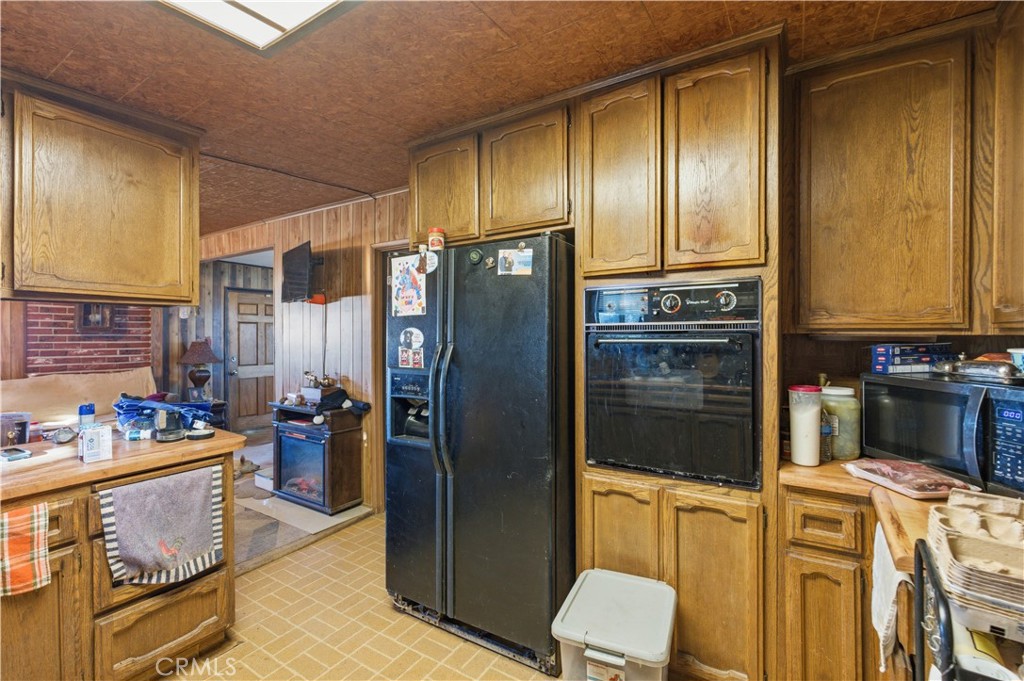 32787 Jagadon Road Lucerne Valley, CA 92356 - Photo 8 of 32 a kitchen with stainless steel appliances granite countertop a refrigerator and a stove top oven