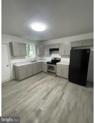 a large kitchen with a stove a sink dishwasher and a refrigerator