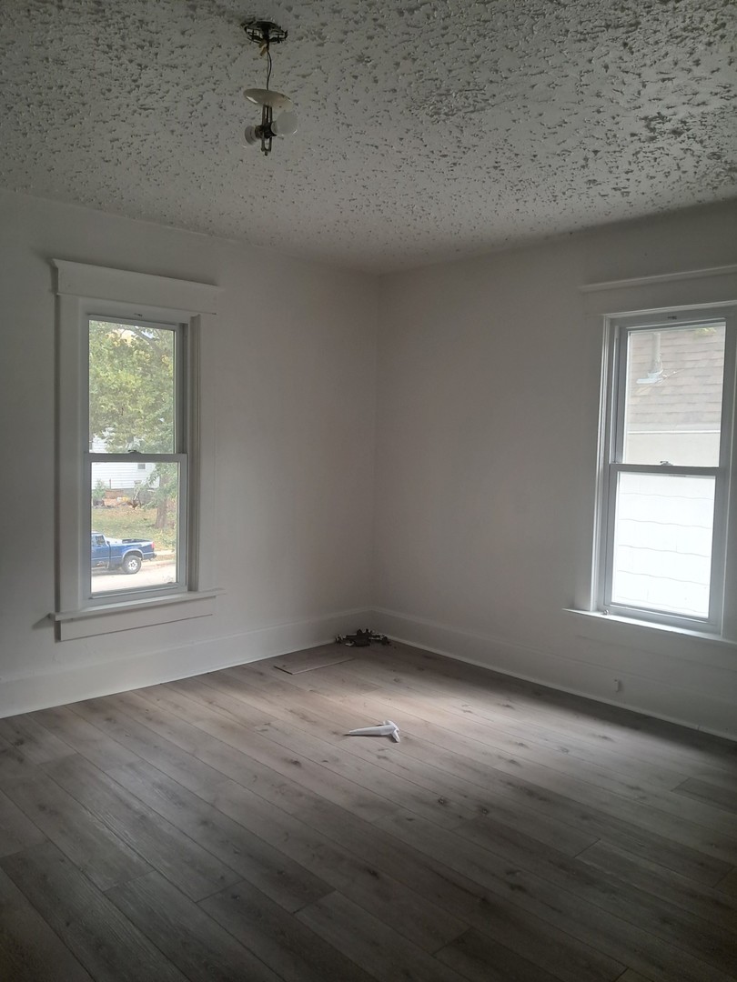 507 6th Avenue Sterling, IL 61081 - Photo 6 of 12 an empty room with wooden floor and windows