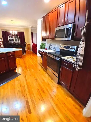 a front view of a house with a garden and trees