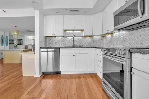 a kitchen with granite countertop white cabinets and white appliances