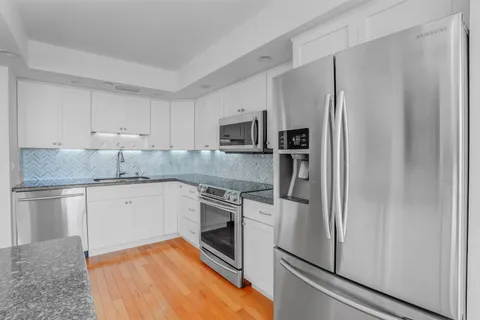 a kitchen with granite countertop stainless steel appliances and wooden cabinets