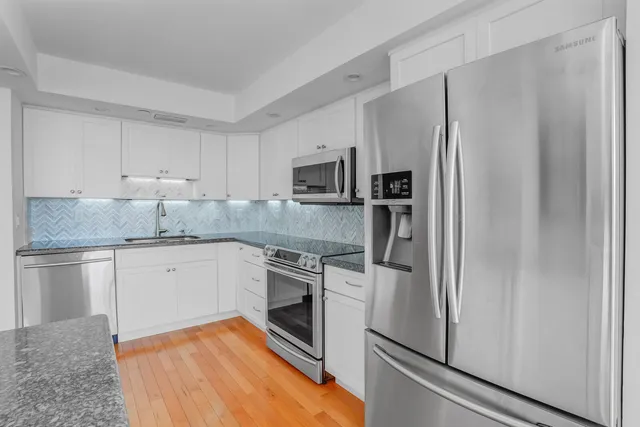 a kitchen with granite countertop stainless steel appliances and wooden cabinets