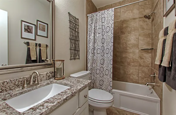 a living room with couches and kitchen view with wooden floor