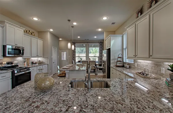 a kitchen with sink refrigerator and microwave