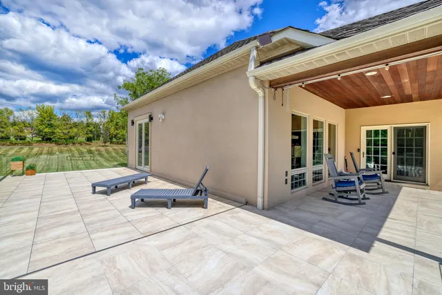 a view of a house with a big yard and large trees