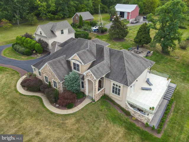 an aerial view of residential house with outdoor space and trees all around