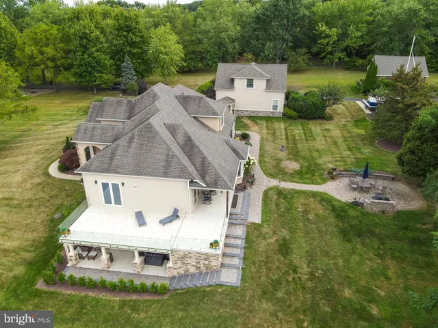 an aerial view of a house with backyard outdoor seating and green space