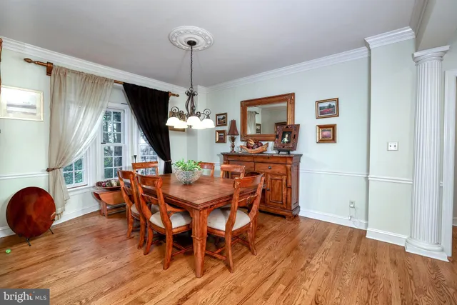 a dining room with furniture a chandelier and wooden floor