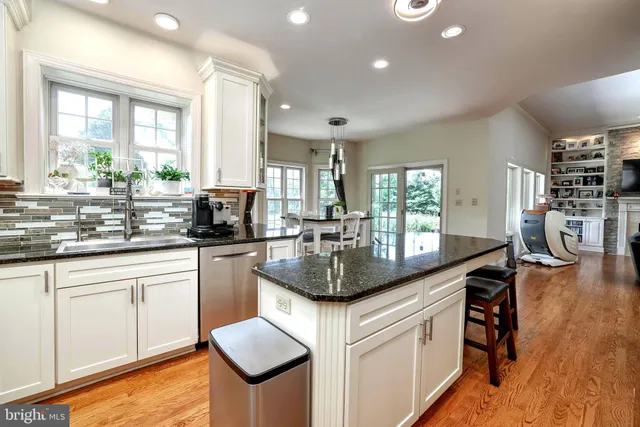 a kitchen with granite countertop kitchen island wooden floors granite counter and chairs