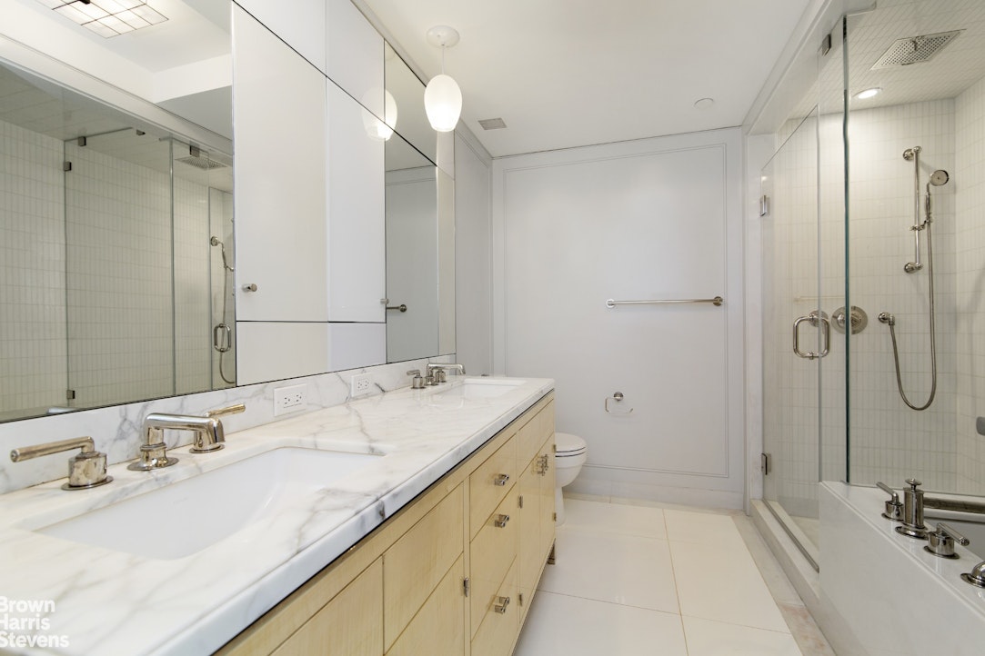 21 East 61st Street, Unit 3C Manhattan, NY 10065 - Photo 3 of 6 a bathroom with a sink double vanity and a mirror