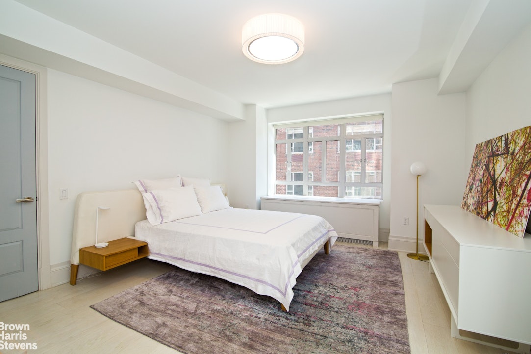 21 East 61st Street, Unit 3C Manhattan, NY 10065 - Photo 4 of 6 a bedroom with a bed and a window
