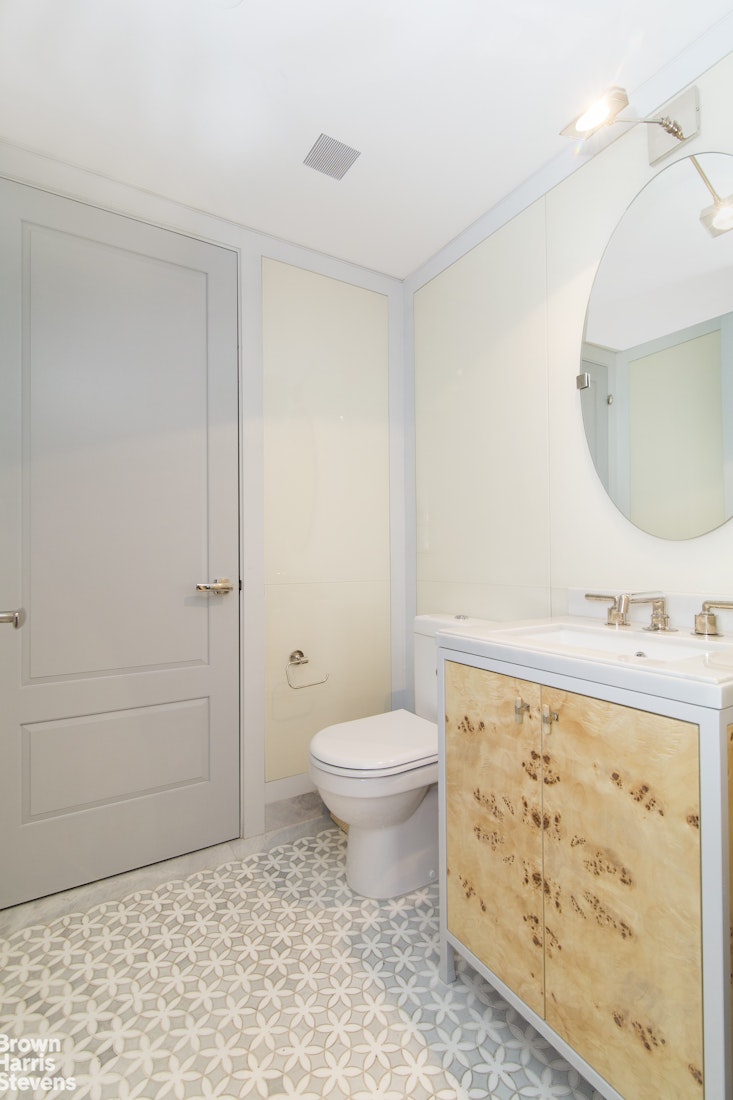 21 East 61st Street, Unit 3C Manhattan, NY 10065 - Photo 5 of 6 a bathroom with a sink a toilet and shower