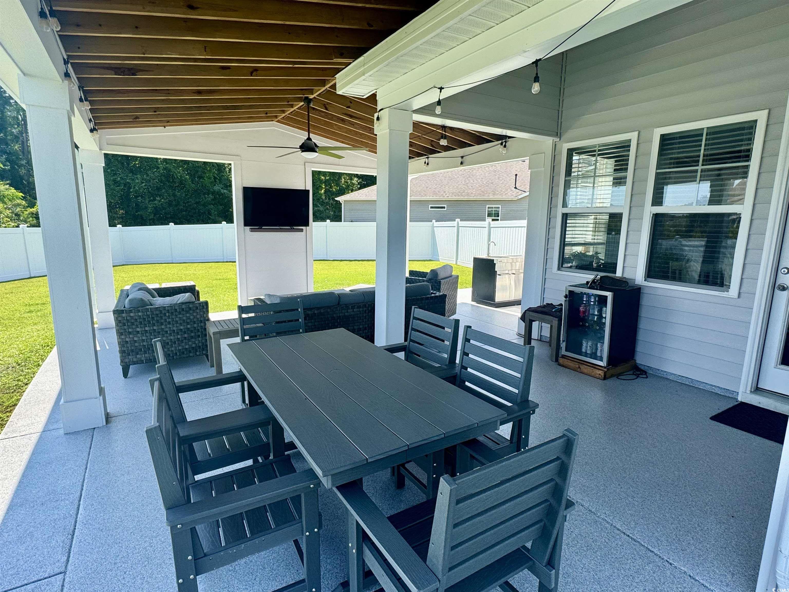 405 Spring View Little River, SC 29566 - Photo 16 of 40 Fenced backyard featuring a patio area, outdoor dining space, and ceiling fan