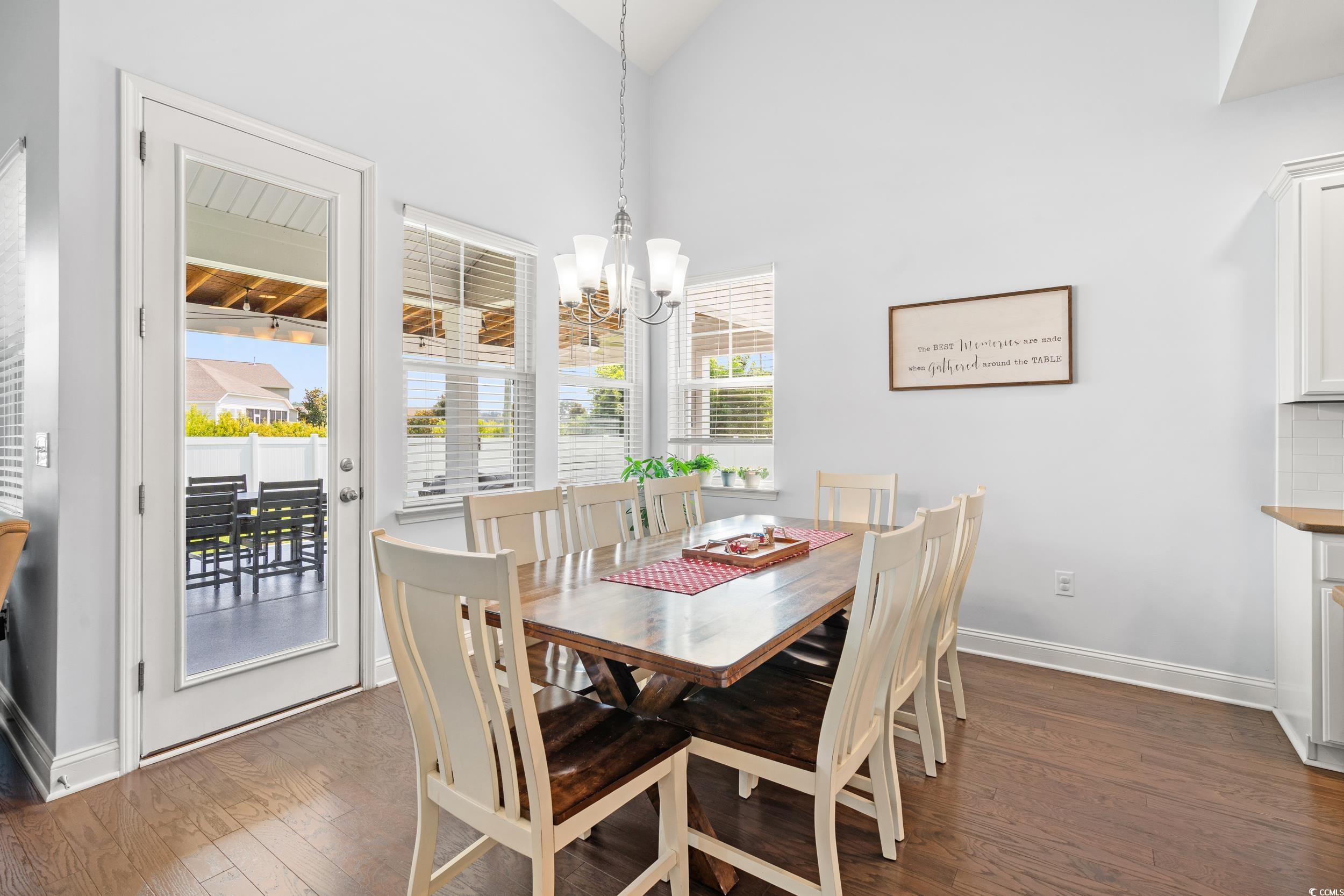 405 Spring View Little River, SC 29566 - Photo 18 of 40 Dining room featuring dark wood-type flooring, a chandelier, and vaulted ceiling