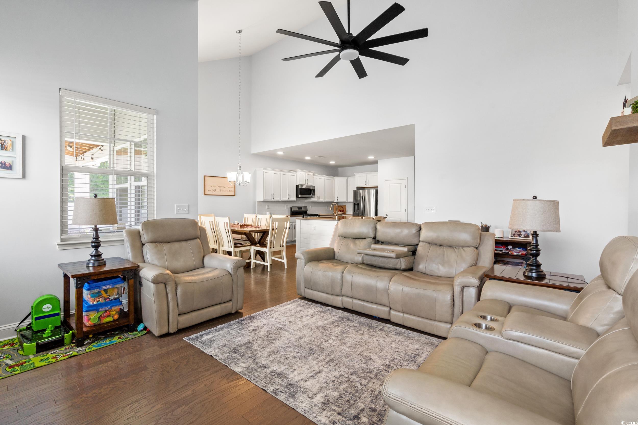 405 Spring View Little River, SC 29566 - Photo 8 of 40 Living area featuring ceiling fan, dark wood-style floors, high vaulted ceiling, and a chandelier