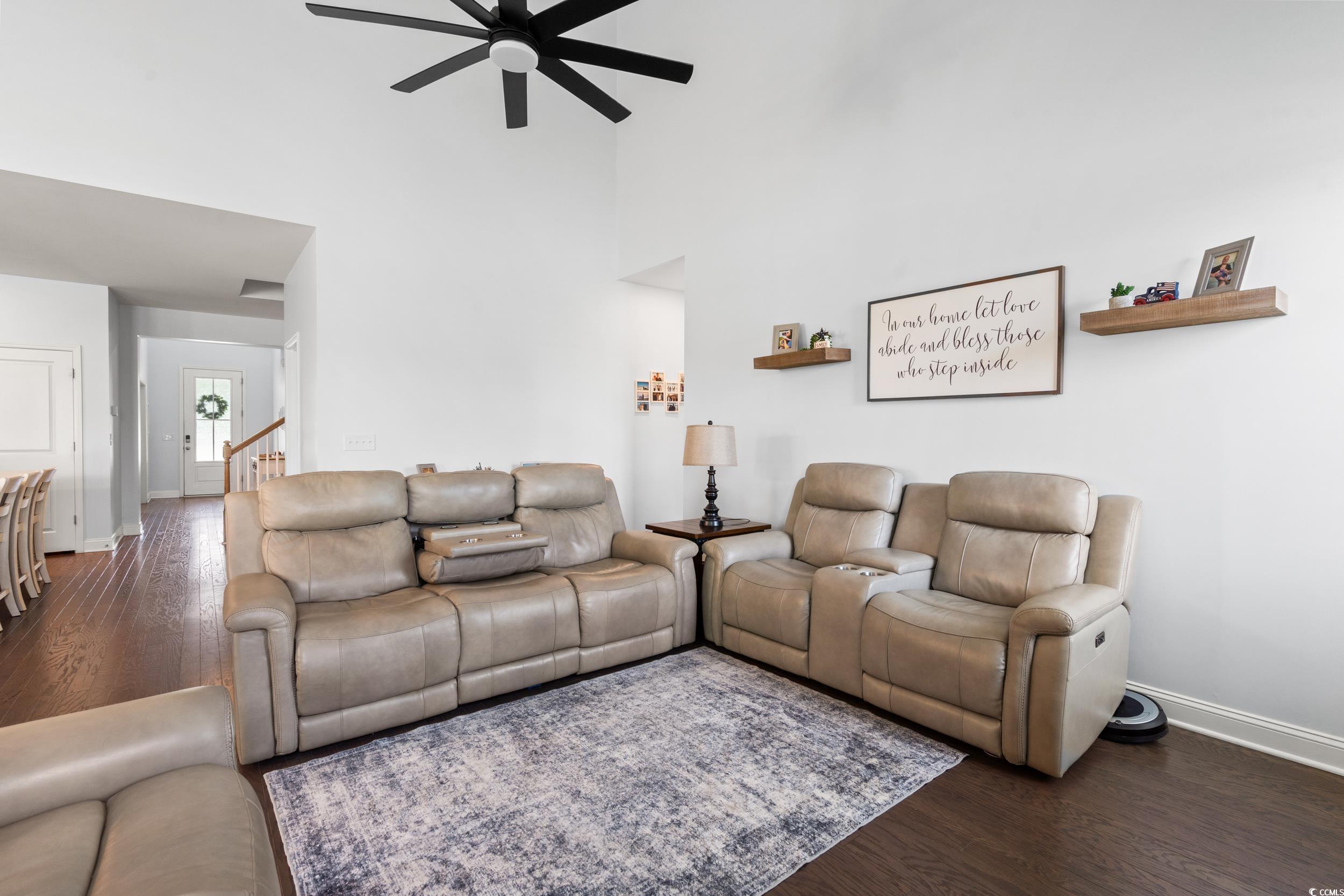 405 Spring View Little River, SC 29566 - Photo 9 of 40 Living room featuring a ceiling fan, dark wood-type flooring, and a high ceiling