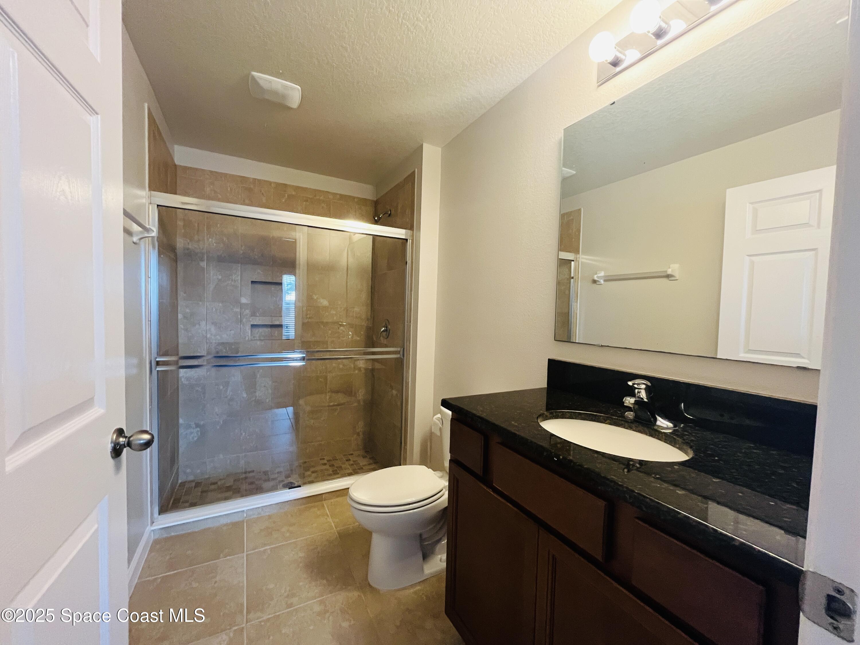 4017 Meander Place, Unit 103 Rockledge, FL 32955 - Photo 6 of 10 a bathroom with a granite countertop sink toilet and shower