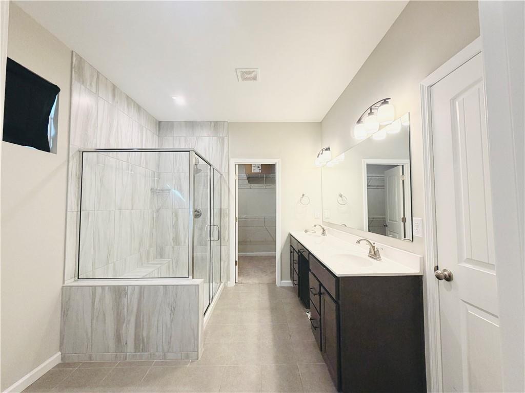 607 Michigan Circle Hoschton, GA 30548 - Photo 12 of 27 a bathroom with a sink a mirror and a shower