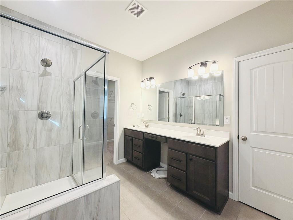 607 Michigan Circle Hoschton, GA 30548 - Photo 13 of 27 a bathroom with a double vanity sink mirror and shower