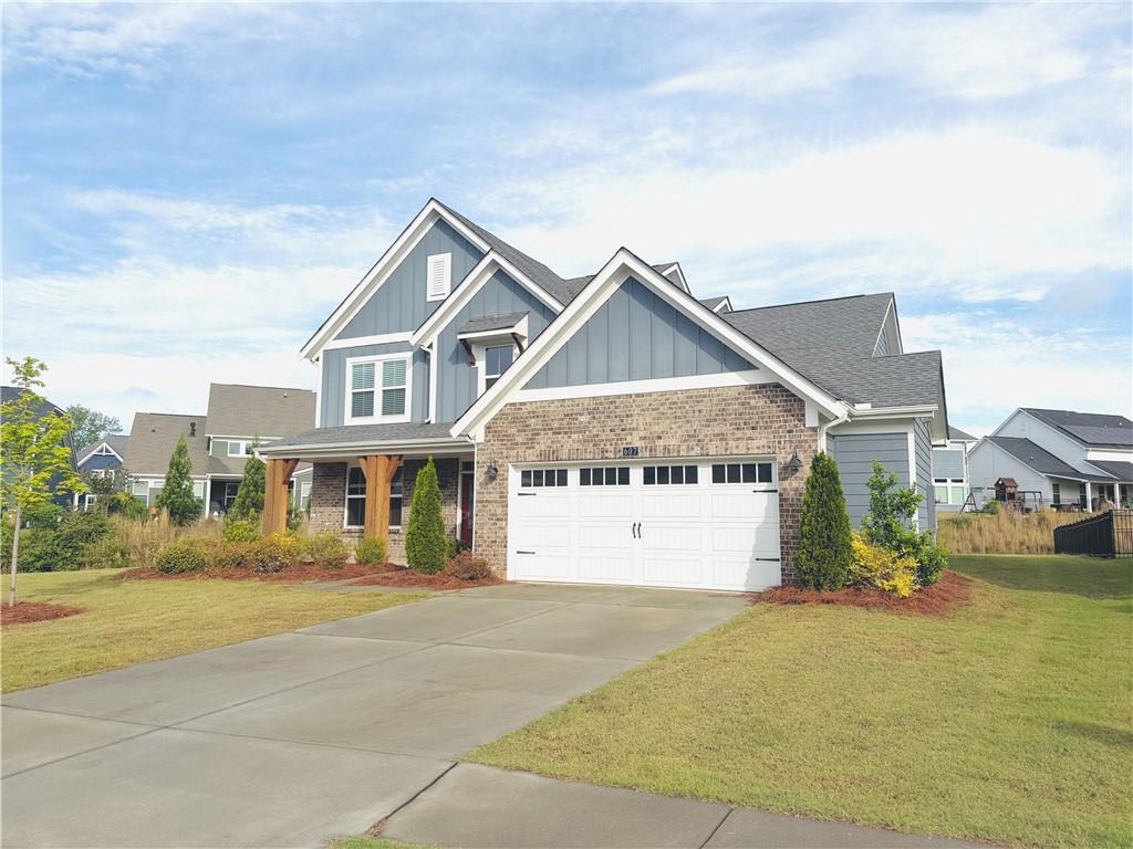 607 Michigan Circle Hoschton, GA 30548 - Photo 2 of 27 a front view of a house with a garden