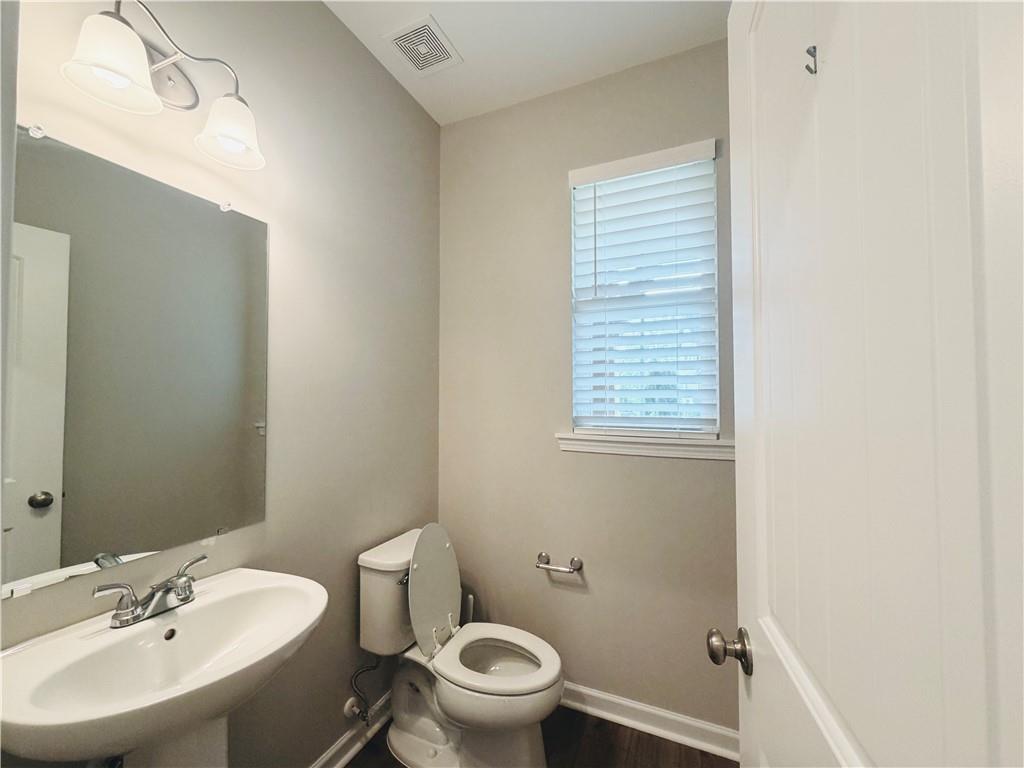 607 Michigan Circle Hoschton, GA 30548 - Photo 24 of 27 a bathroom with a sink a toilet and a mirror