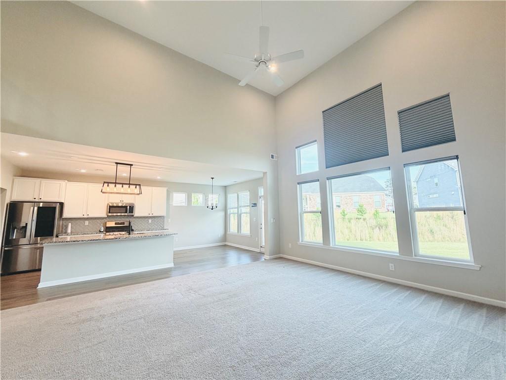 607 Michigan Circle Hoschton, GA 30548 - Photo 3 of 27 a open kitchen with stainless steel appliances granite countertop a stove and a refrigerator with white cabinets