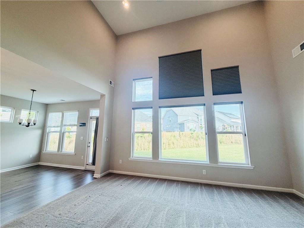 607 Michigan Circle Hoschton, GA 30548 - Photo 9 of 27 a view of an empty room with a window and wooden floor