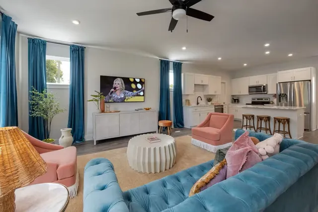 a living room with furniture kitchen view and a large window