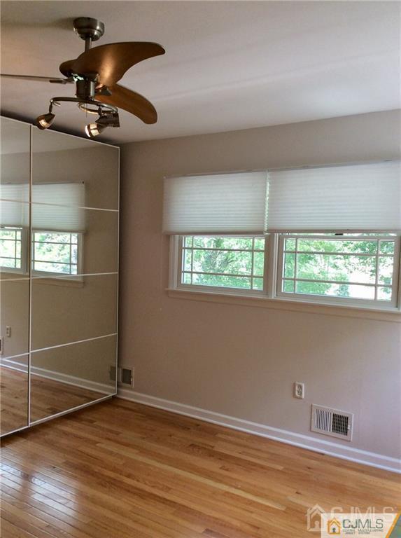 24 Rath Lane East Brunswick, NJ 08816 - Photo 20 of 25 en empty room with window and wooden floor