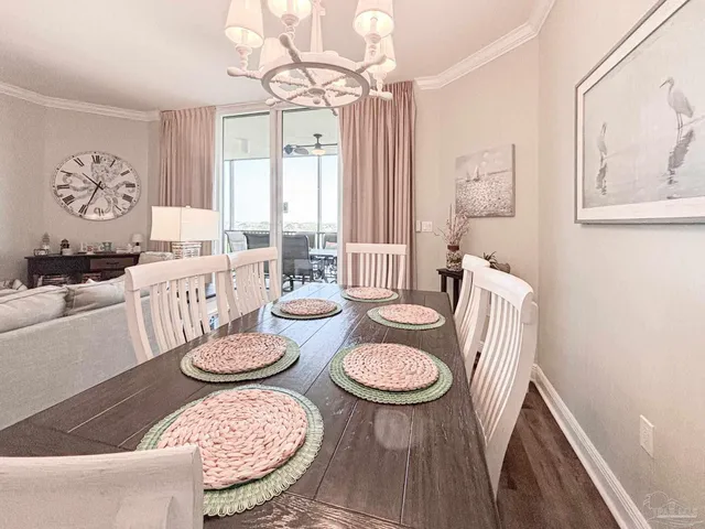 a view of a dining room with furniture a chandelier and wooden floor