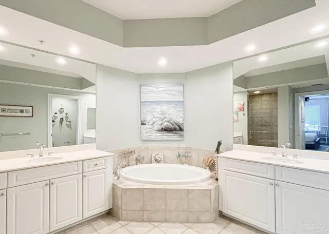 a bathroom with a double vanity sink mirror and bathtub