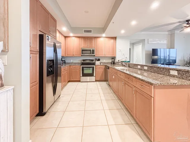 a kitchen with stainless steel appliances granite countertop a refrigerator and a stove top oven