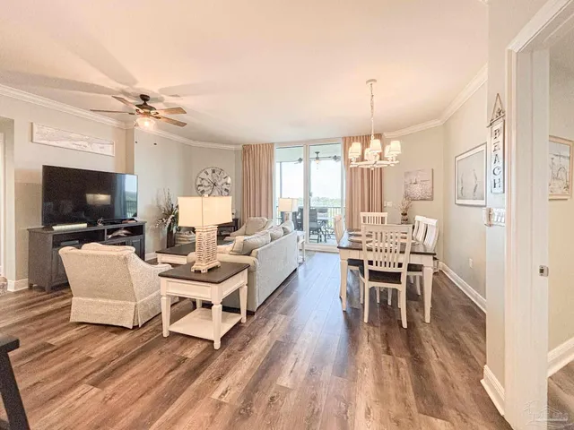 a living room with furniture a flat screen tv and a chandelier
