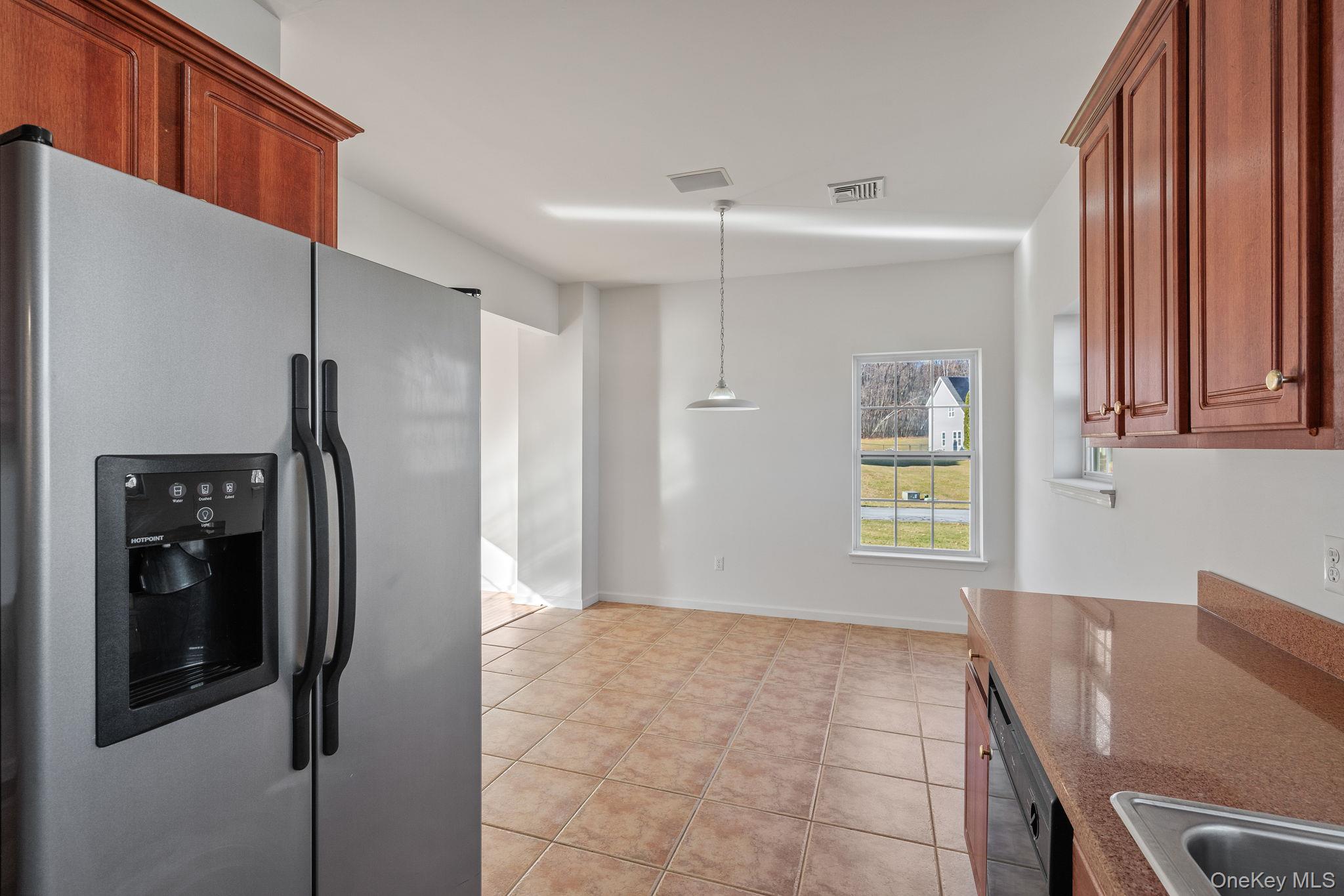 17 Carmella Road Highland, NY 12528 - Photo 18 of 48 Kitchen featuring stainless steel fridge, light tile patterned floors, pendant lighting, dark stone countertops, and black dishwasher