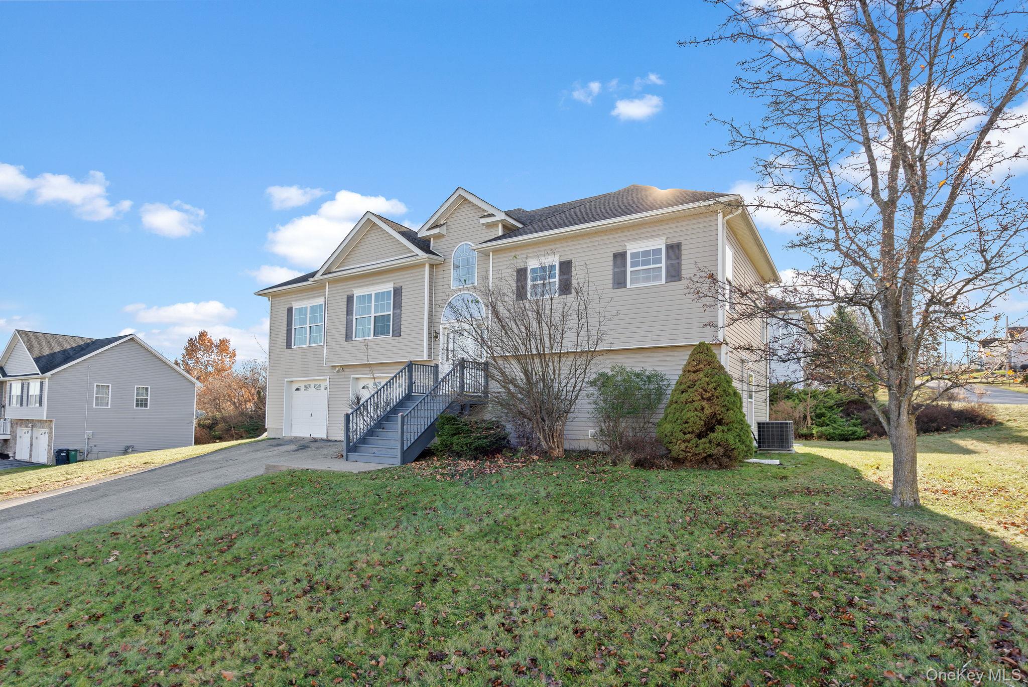 17 Carmella Road Highland, NY 12528 - Photo 3 of 48 View of front of house with asphalt driveway, an attached garage, stairway, and a front lawn