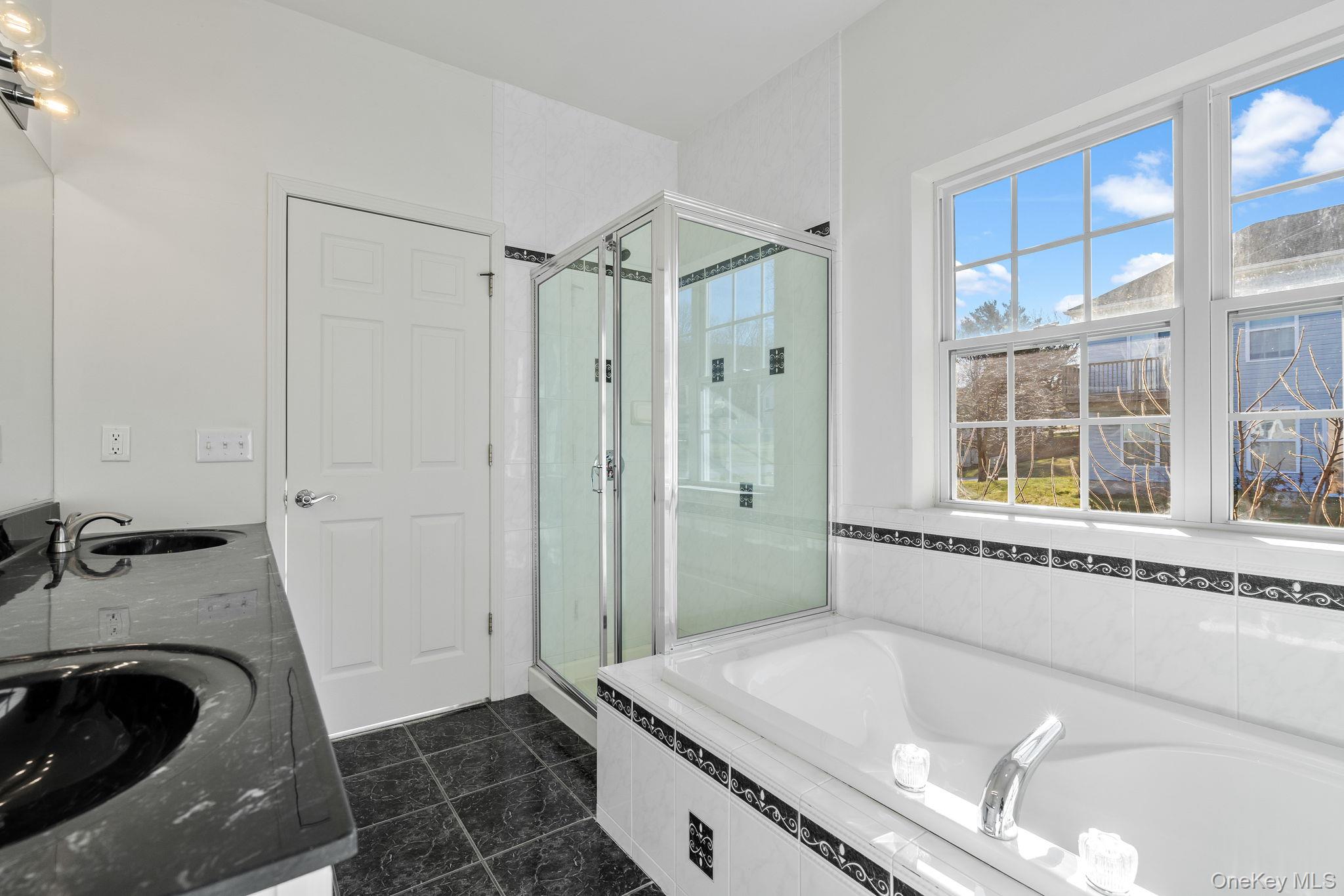17 Carmella Road Highland, NY 12528 - Photo 32 of 48 Bathroom featuring a bath, double vanity, a stall shower, and dark tile patterned floors
