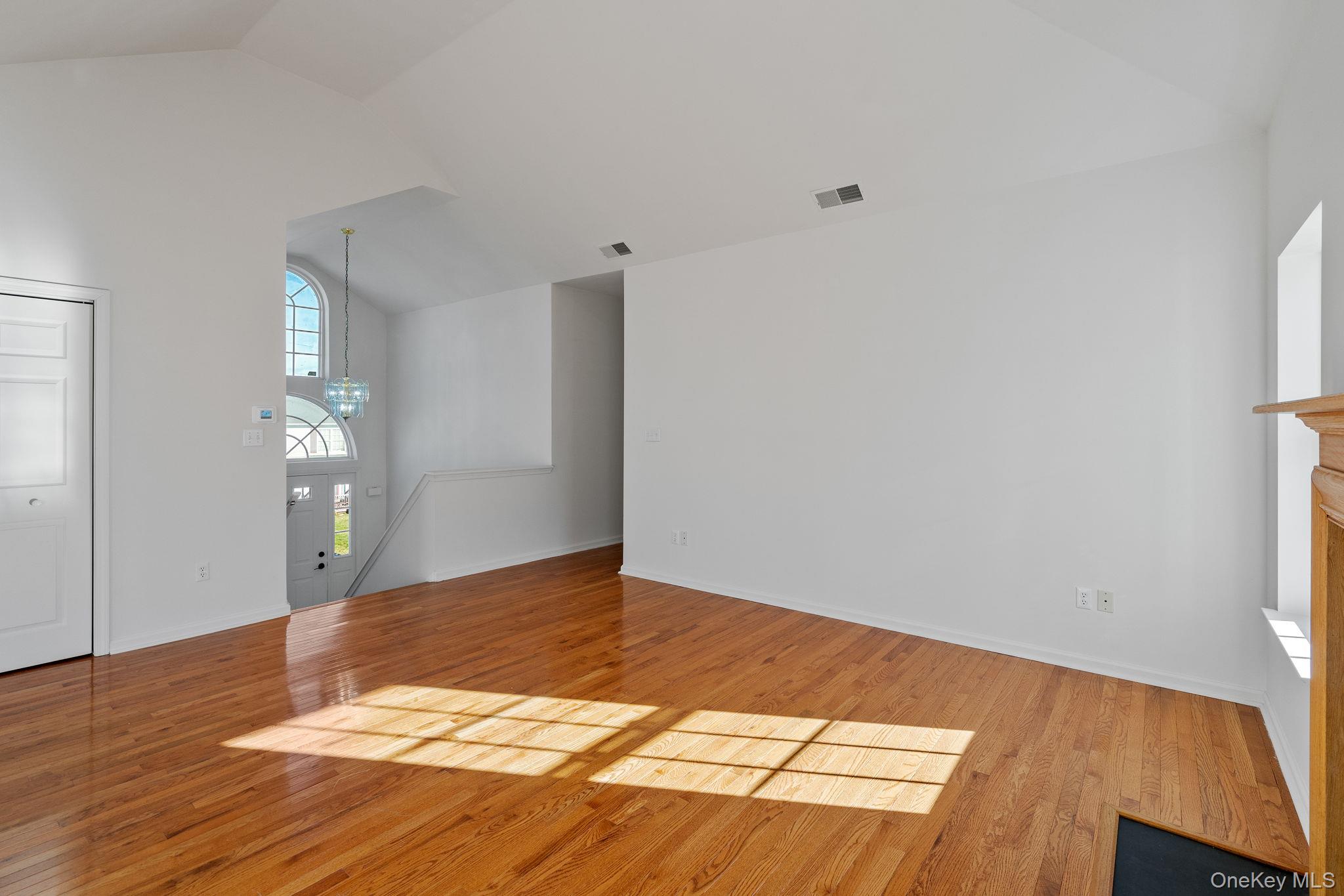 17 Carmella Road Highland, NY 12528 - Photo 9 of 48 Unfurnished living room featuring light wood finished floors, a chandelier, and high vaulted ceiling