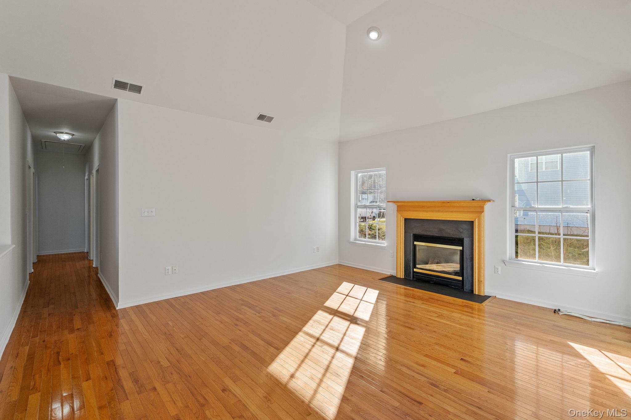 17 Carmella Road Highland, NY 12528 - Photo 10 of 48 Unfurnished living room featuring a fireplace with flush hearth, light wood-style floors, and attic access