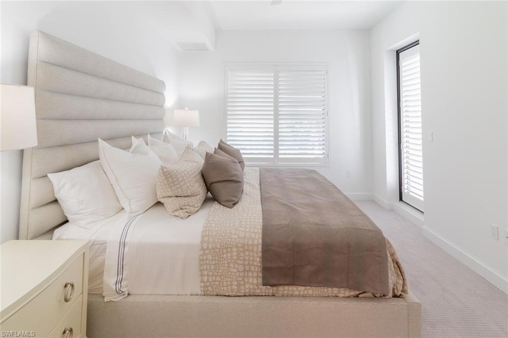 1125 Central Avenue, Unit 373 Naples, FL 34102 - Photo 17 of 49 a bed sitting in a bedroom next to a window