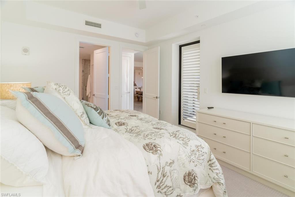 1125 Central Avenue, Unit 373 Naples, FL 34102 - Photo 21 of 49 a bedroom with a bed and a flat screen tv in the kitchen