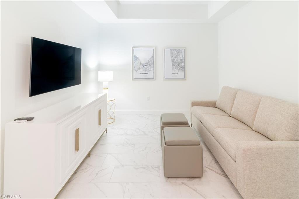 1125 Central Avenue, Unit 373 Naples, FL 34102 - Photo 26 of 49 a living room with furniture and a flat screen tv