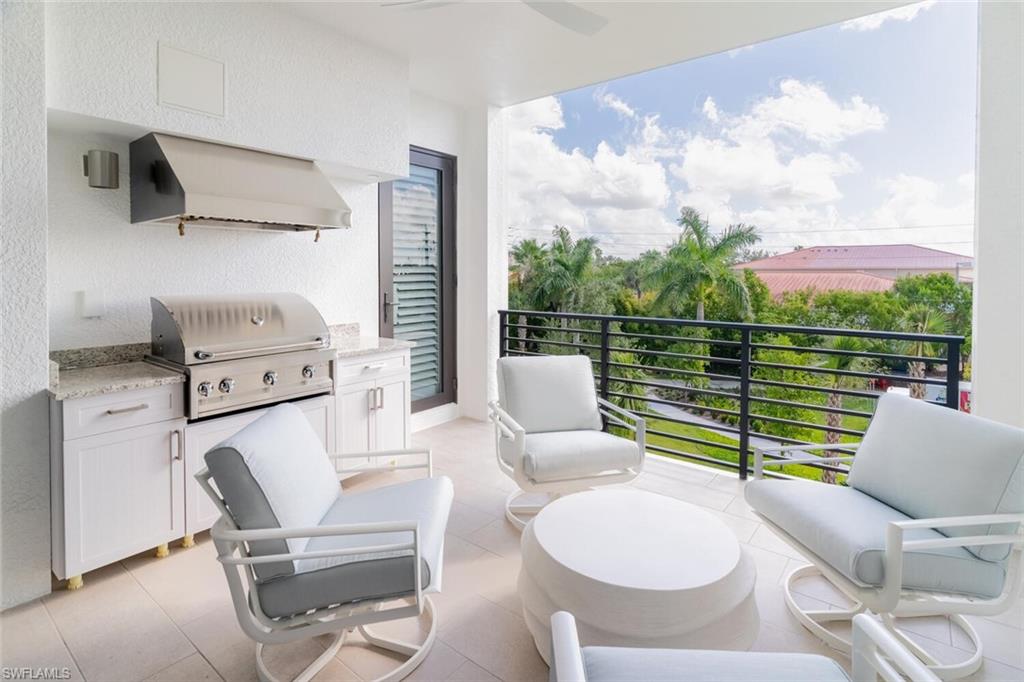 1125 Central Avenue, Unit 373 Naples, FL 34102 - Photo 29 of 49 a balcony with furniture and a floor to ceiling window
