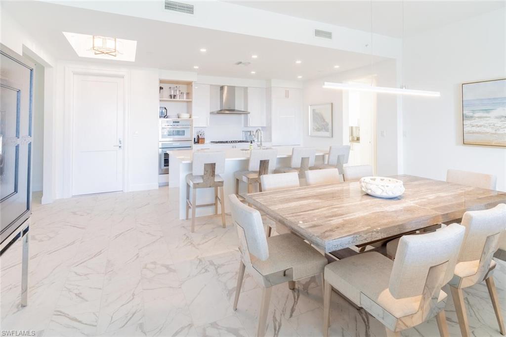 1125 Central Avenue, Unit 373 Naples, FL 34102 - Photo 6 of 49 a dining room with kitchen island a table and chairs in it