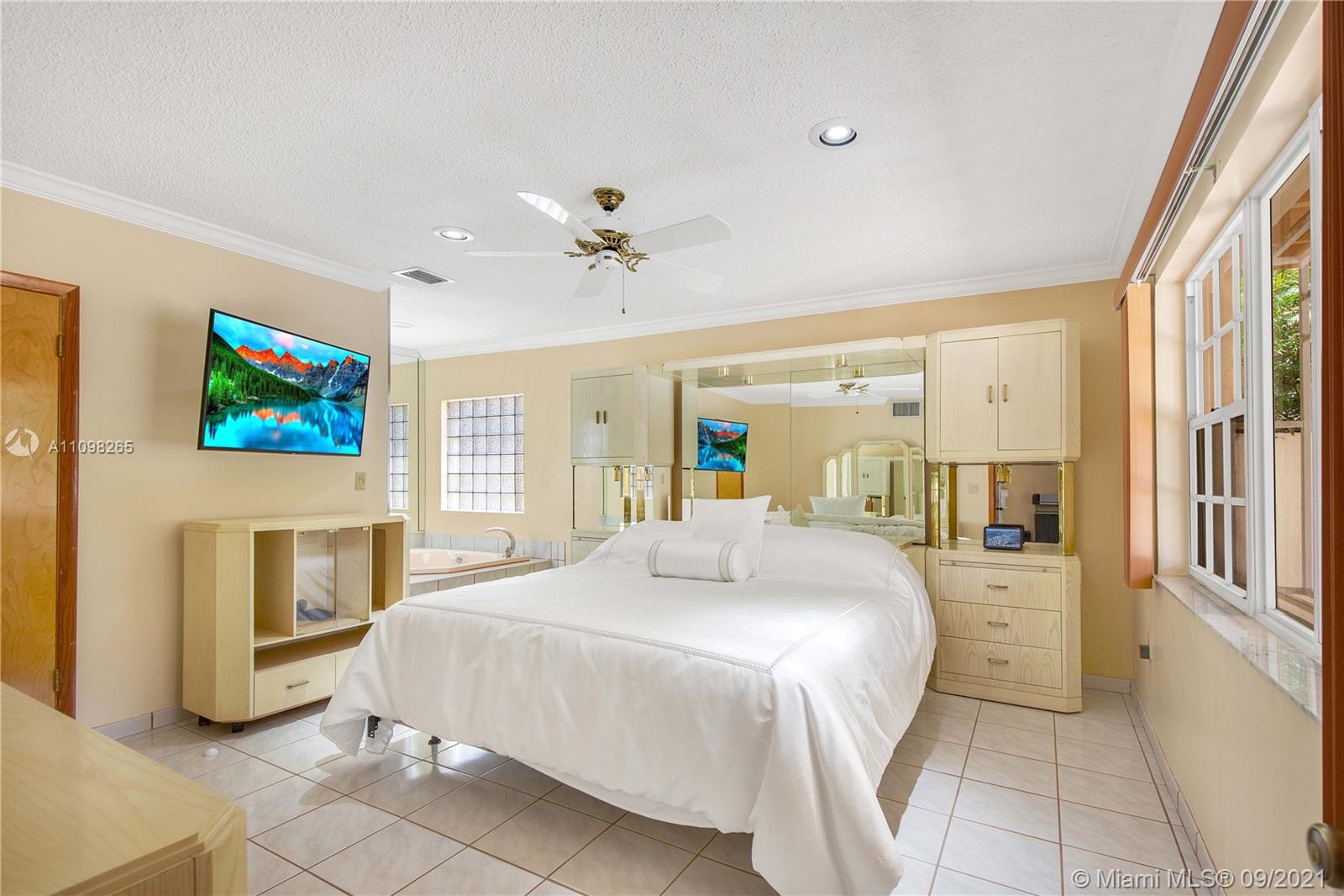 620 Southwest 22nd Road Miami, FL 33129 - Photo 23 of 53 a spacious bedroom with a balcony a bed and a flat screen tv