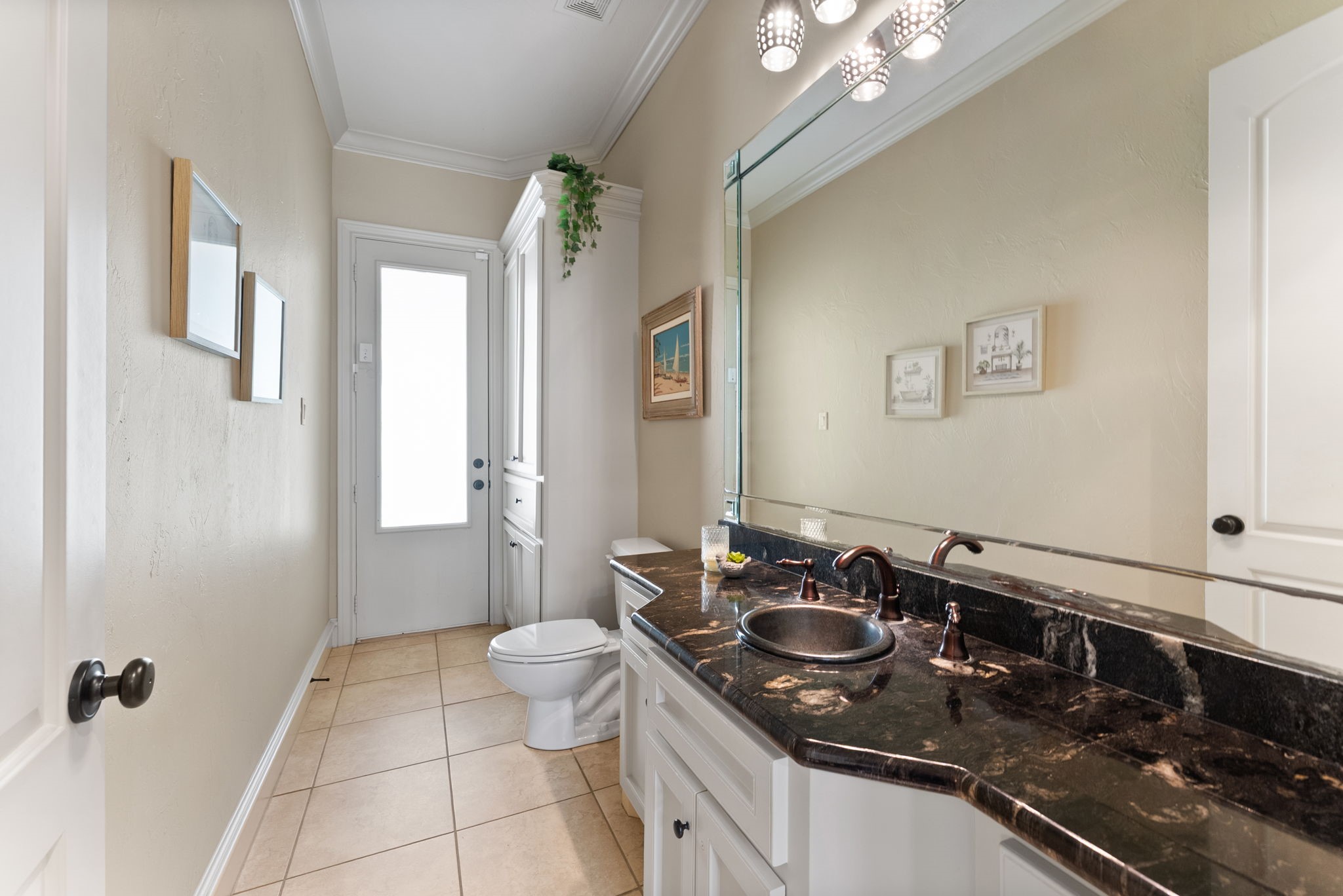 3907 Rayford Road Spring, TX 77386 - Photo 13 of 38 Conveniently located off the foyer and study, this Powder Bath features a large vanity with granite countertops, an oversized mirror, crown molding, a built-in linen closet (perfect for swim towels), and direct access to the back patio—perfect for use as a pool bath.