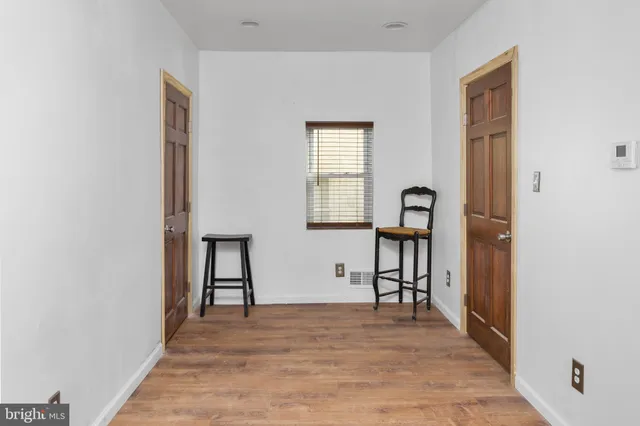 a view of empty room with a window and wooden floor