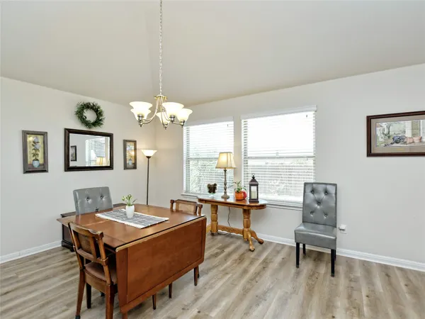 a view of a dining room with furniture a kitchen and chandelier