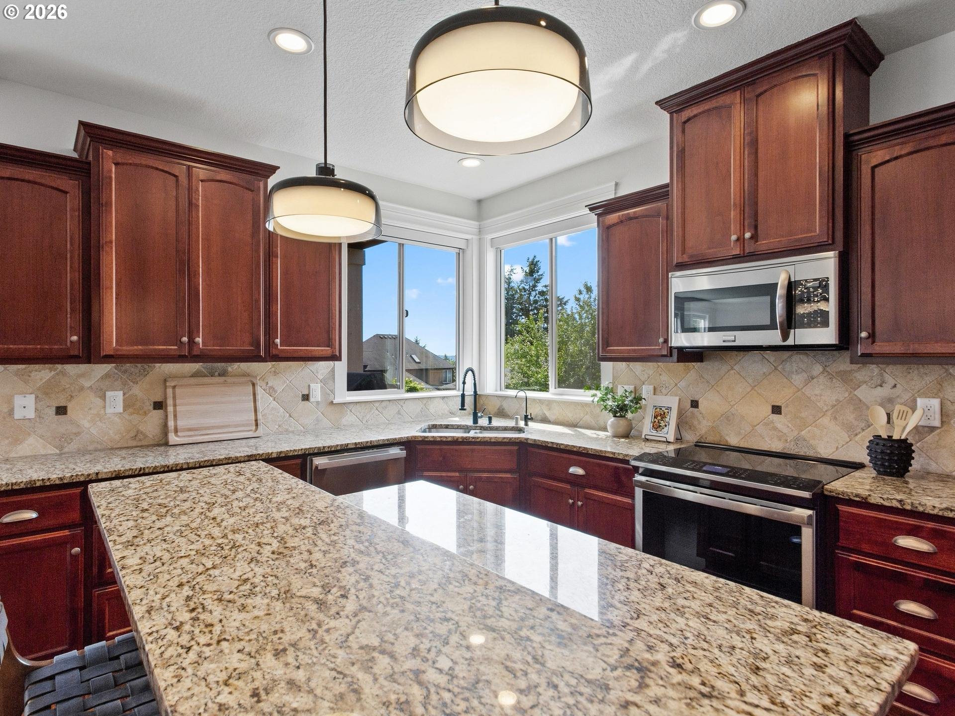 1012 Northwest Goodwin Street Camas, WA 98607 - Photo 9 of 44 a kitchen with stainless steel appliances granite countertop wooden cabinets a stove a sink and a microwave