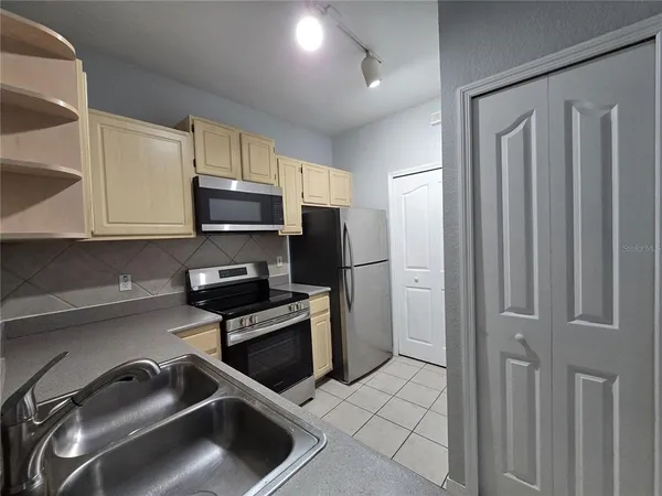 a kitchen with granite countertop a stove sink and refrigerator